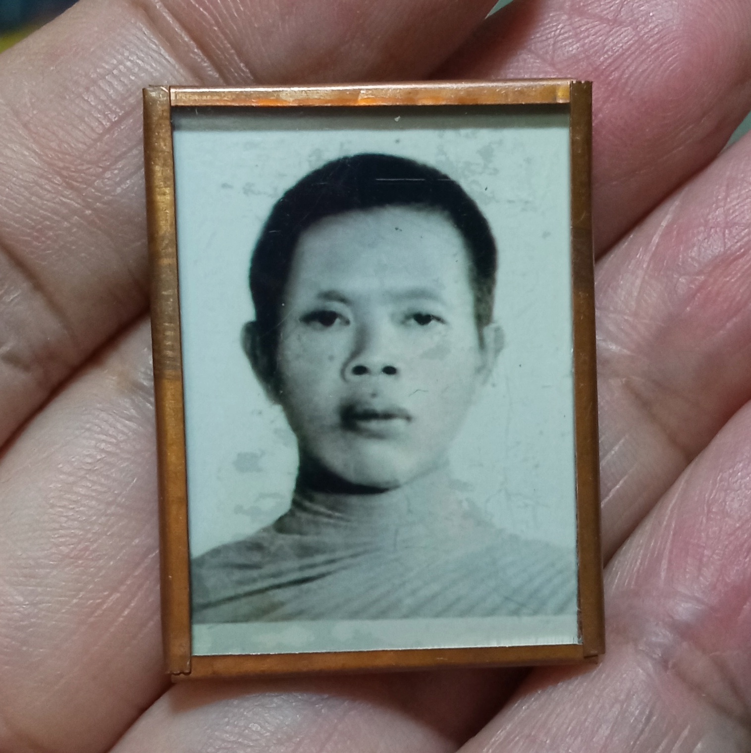 หลวงพ่อคูณ วัดบ้านไร่ รูปถ่ายหน้าหนุ่มอัดกระจกหุ้มด้วยแผ่นตะกรุดทองแดงจาร มือ หลวงพ่อคูณ ออกที่วัดปรก (วัดราษฏร์บำรุง) จ.นครราชส ีมา ปี 2536 มีรอยจารเก่า